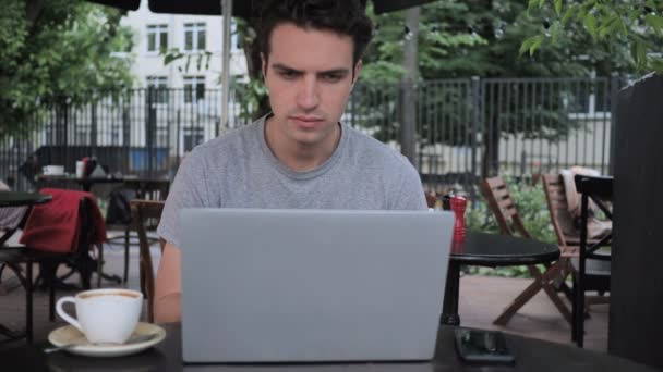 Zastanawiasz się, do człowieka za pomocą laptopa siedząc w Cafe Terrace - Materiał filmowy, wideo