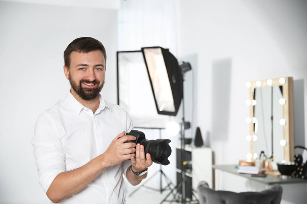 Professional photographer with camera in photo studio - Photo, image