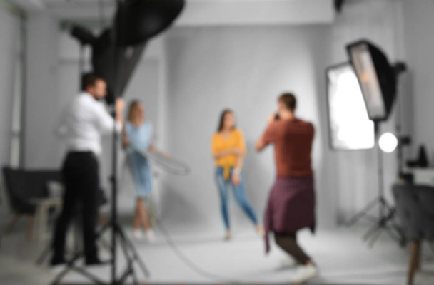 Blurred view of professional team working with model in photo studio - Фото, зображення