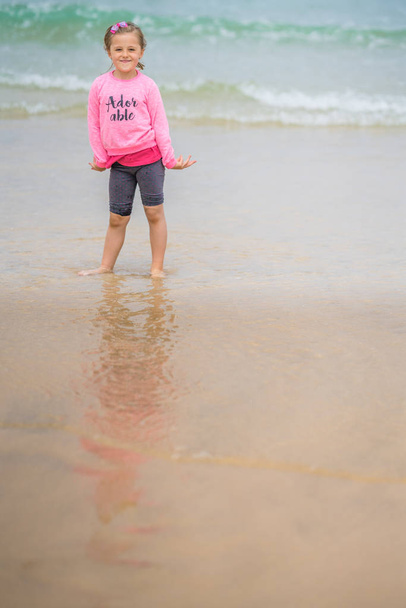 A roztomilý kavkazských holčička ve vodě na pláži v St. Ives v Cornwallu, Anglie, Velká Británie - Fotografie, Obrázek