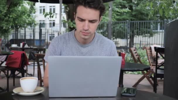 Człowiek za pomocą smartfona i pracy na laptopie w Cafe Terrace - Materiał filmowy, wideo