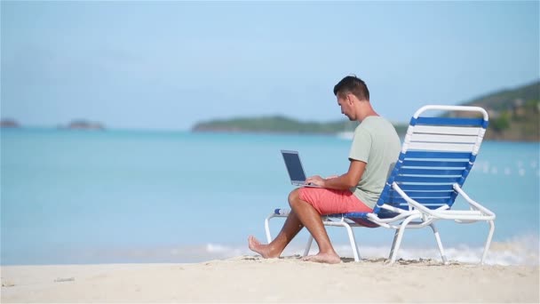 junger Mann mit Laptop am tropischen Strand. - Filmmaterial, Video