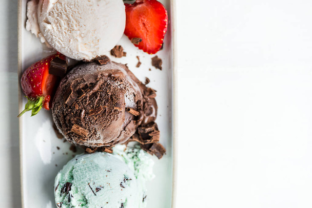 Výběr kopečky zmrzliny různých máta, čokoládu a jahody na oválný talíř, pohled shora - Fotografie, Obrázek