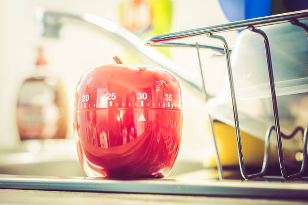 30 Minuti - Timer rosso dell'uovo della cucina su un lavandino con i piatti
 - Foto, immagini