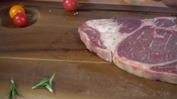 Close up van gastronomische chef-kok of kok kruiden vers stuk van deli stuk rundvlees met zeezout en geaard pikante pepers. - Video
