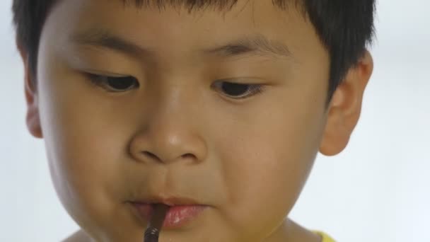 Χαριτωμένο αγόρι πόσιμο νερό από άχυρο σε λευκό φόντο, - Πλάνα, βίντεο