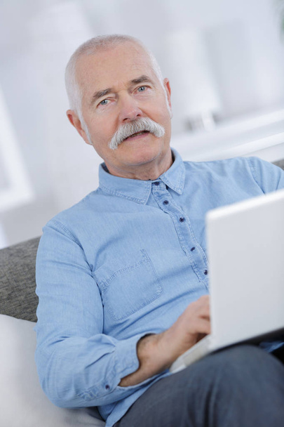 portrait of senior man using laptop at home - Valokuva, kuva