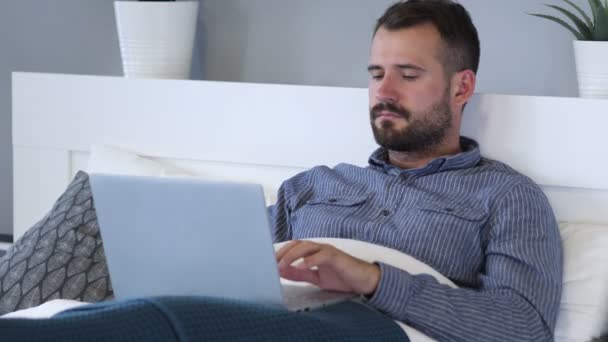 Man Working on Laptop while Relaxing in Bed - Footage, Video