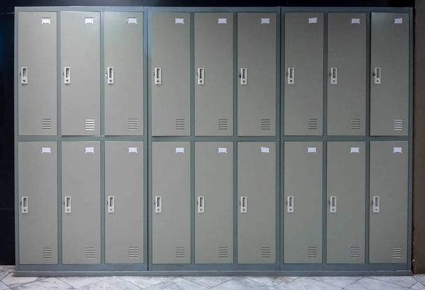 Armários de metal cinza escola ou ginásio com alças e fechaduras em duas fileiras
 - Foto, Imagem