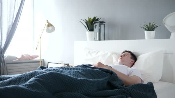 νεαρός άνδρας κοιμάται στο κρεβάτι - Πλάνα, βίντεο