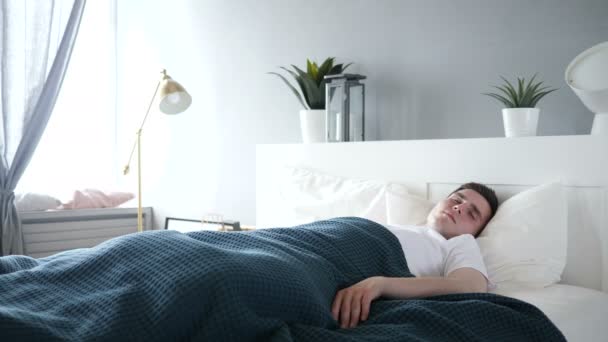 mężczyzna śpiący w łóżku - Materiał filmowy, wideo