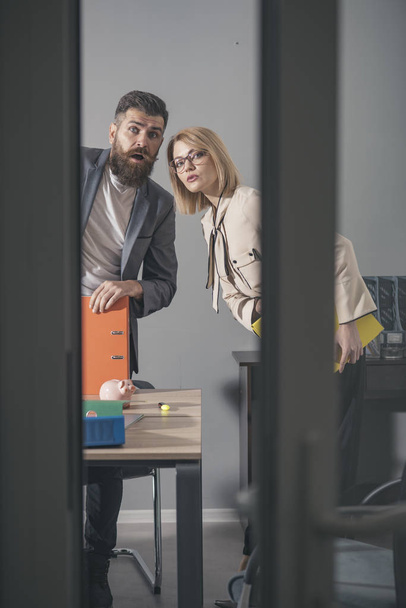 Young business couple standing in modern office environment binders - 写真・画像