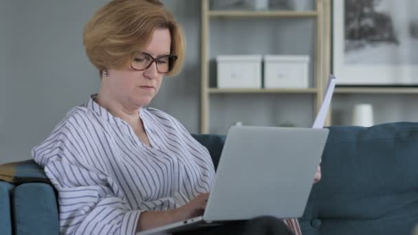 Penisve Old Senior Woman Doing Paperwork and using Laptop - 映像、動画
