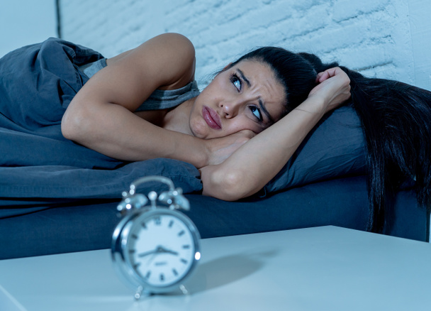 young beautiful hispanic woman at home bedroom lying in bed late at night trying to sleep suffering insomnia sleeping disorder or scared on nightmares looking sad worried in mental health concept - Photo, Image