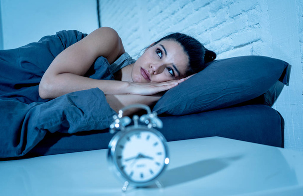 young beautiful hispanic woman at home bedroom lying in bed late at night trying to sleep suffering insomnia sleeping disorder or scared on nightmares looking sad worried in mental health concept - Fotografie, Obrázek