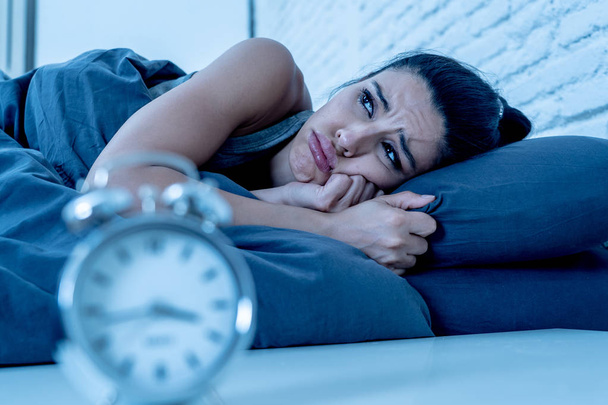 young beautiful hispanic woman at home bedroom lying in bed late at night trying to sleep suffering insomnia sleeping disorder or scared on nightmares looking sad worried in mental health concept - Photo, Image