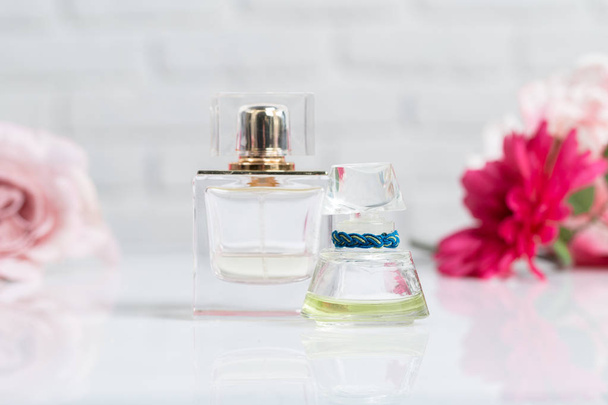 female perfume bottles with flowers, close-up  - Фото, изображение