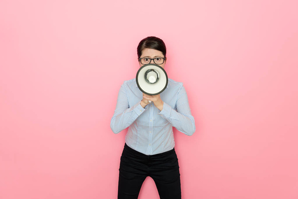 business lady using loudspeaker talking face to the camera isolated on pink background - Foto, immagini