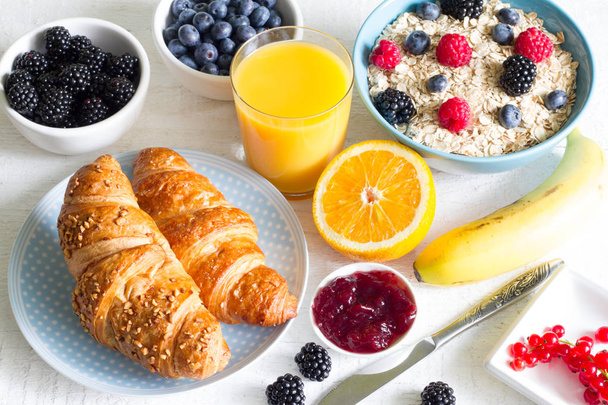 Croissant and healthy breakfast on white table - Фото, изображение