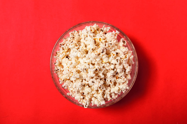 Salt popcorn in bowl on red table    - Foto, Bild