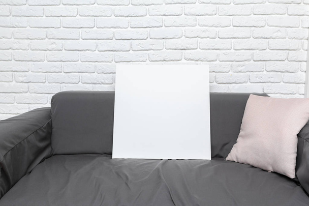 Tavola bianca bianca su divano grigio
 - Foto, immagini