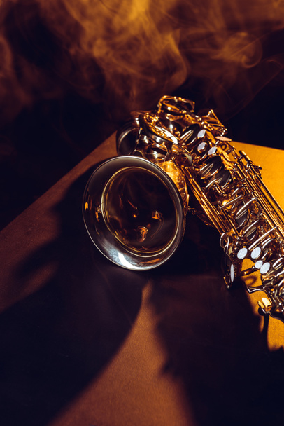 vista de cerca del saxofón brillante en humo y retroiluminado en negro
   - Foto, imagen