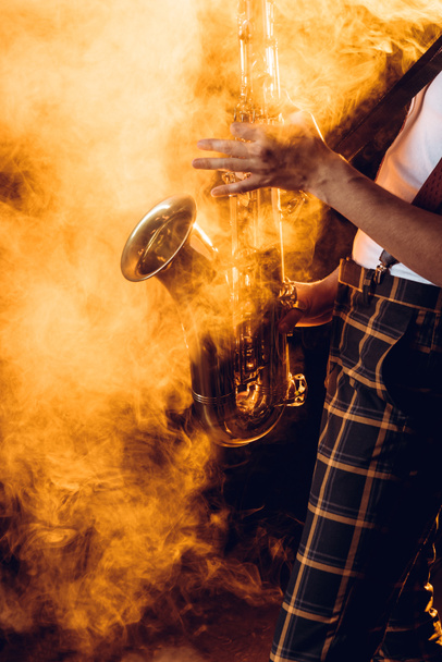 recortado disparo de expresivo joven músico tocando saxofón en el humo
  - Foto, imagen