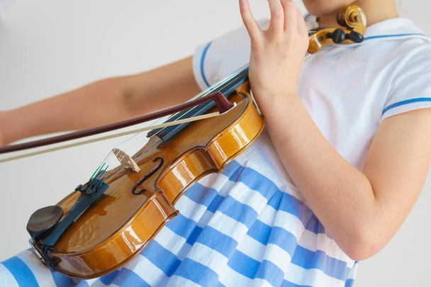 Дівчина грає на скрипці в білій кімнаті
 - Фото, зображення