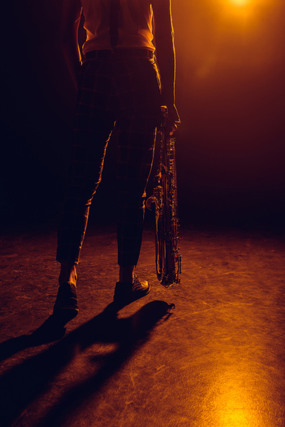 recortado disparo de músico sosteniendo saxofón en el escenario
  - Foto, Imagen