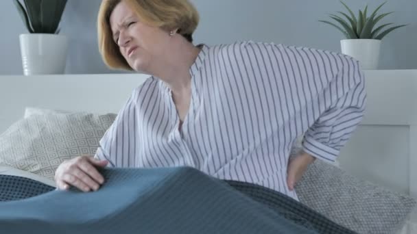 Starší žena s bolestí zad, seděl v posteli - Záběry, video