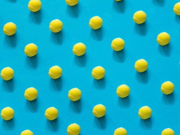Yellow tennis ball patter on blue background - Photo, Image