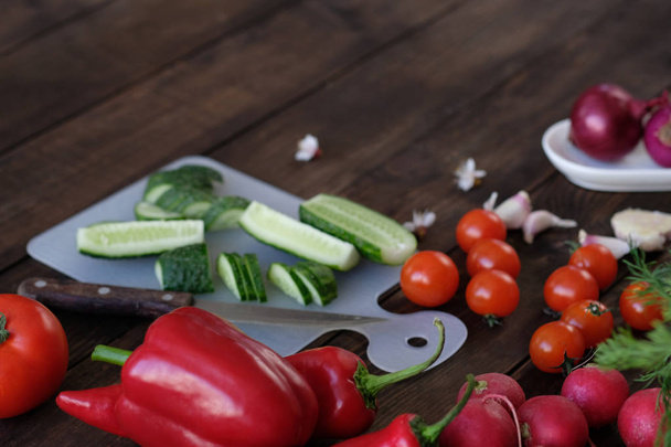 Fresh vegetables sliced for a salad on a cutting board - Фото, изображение