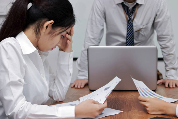 Depresif genç Asya iş kadını elle ofiste toplantı arasında ciddi sorunu muzdarip yüzündeki yorgun. - Fotoğraf, Görsel