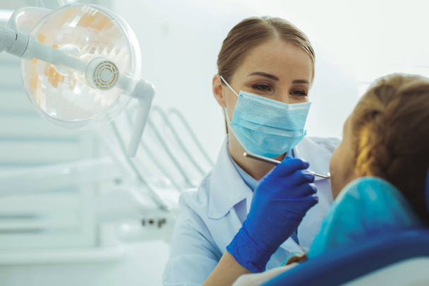 Attentive female person working in dentist surgery - Photo, image