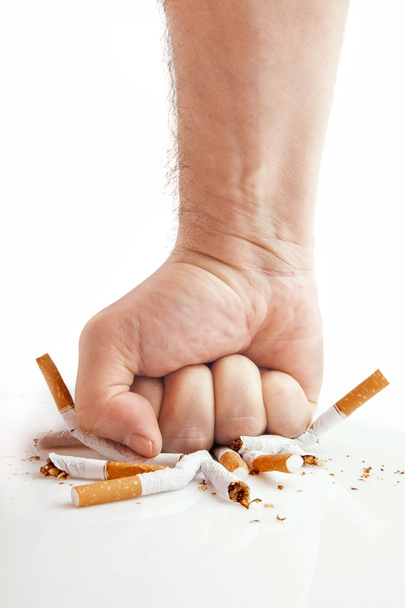 Human fist breaking cigarettes on white background - Photo, Image