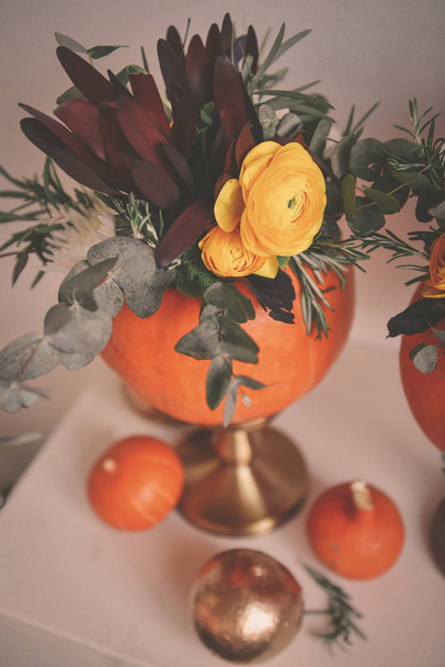 autumn floral bouquet in a pumpkin vase for Halloween. Table set - Foto, immagini