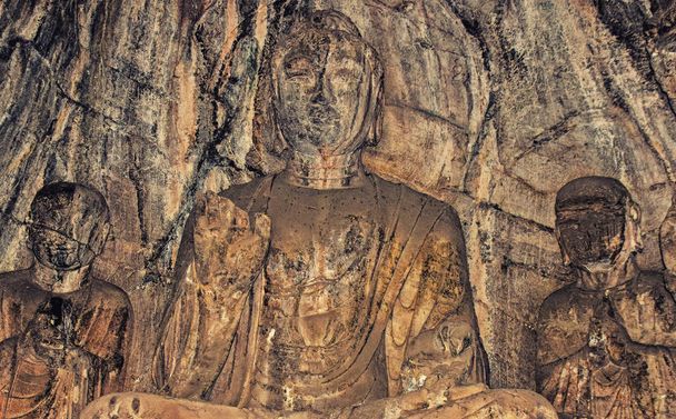 Лоян, Хернан, Китай-25 декабря 2017 года: Скала вырезала статую Будды, исполняющую желания и защищающую от страха. Этот грот до сих пор содержит оригинальную краску для династии Вэй. Взято в Китае Longmen
. - Фото, изображение