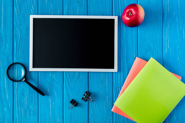 felülnézet üres tábla, apple, papíráru, kék fa háttér  - Fotó, kép