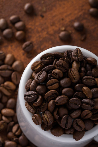 Photo closeup of coffee beans in white cup. Rusty background. Copy space. - Valokuva, kuva