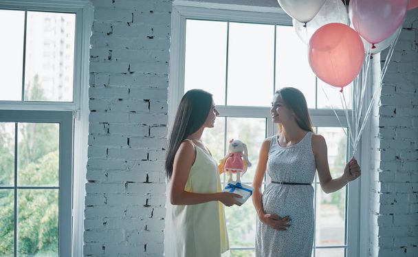 Attractive pregnant woman at home with her female friends. Baby shower. - Foto, imagen