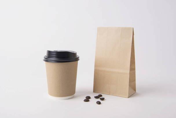 Üres barna táska és kávé papírpohár reklám és a márkaépítés háttér makett-sablon.  - Fotó, kép