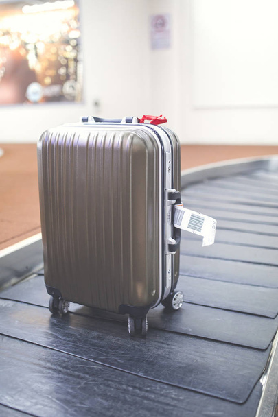 Колісна валіза на багажному поясі в терміналі аеропорту
. - Фото, зображення