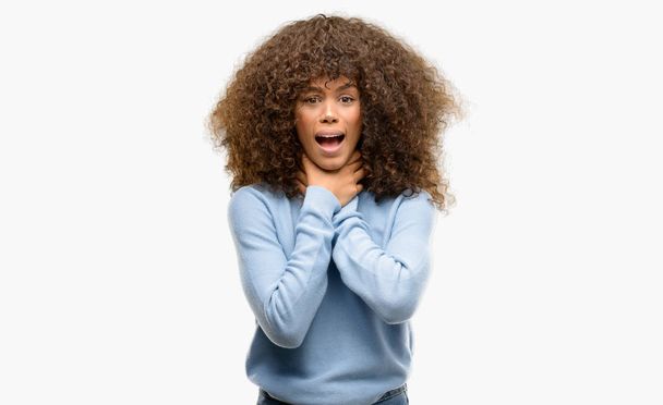 Mujer afroamericana usando un suéter gritando y sofocándose por estrangulamiento doloroso. Problema de salud. Concepto de asfixia y suicidio
. - Foto, imagen