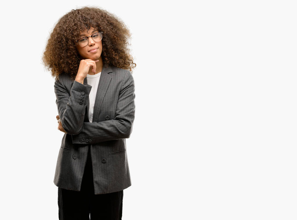Afro-Amerikan iş kadın gözlük ile çene düşünme hakkında soru, dalgın ifade ver. Düşünceli yüzüyle gülümsüyor. Şüphe kavramı. - Fotoğraf, Görsel