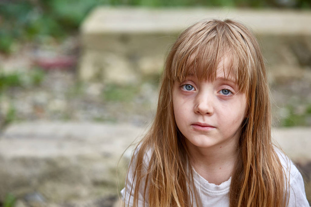 Portrait of sad vulnerable little girl in dirty alley, shallow depth of field. - Photo, Image