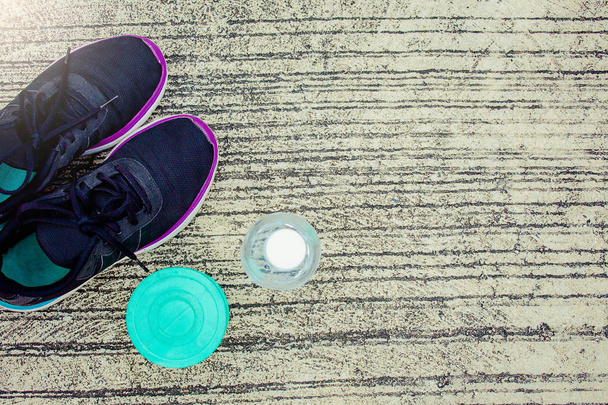 Sportovní obuv s láhev a zelená barva činka na podlaze nebo na ulici metafora Fitness a cvičení koncept cvičení zdraví životní styl svalů s starat se o vaše zdraví kopie pro reklamu - Fotografie, Obrázek