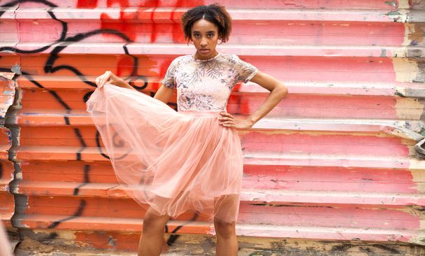 Street fashion model. Portrait of an African young woman in pink dress - Photo, Image