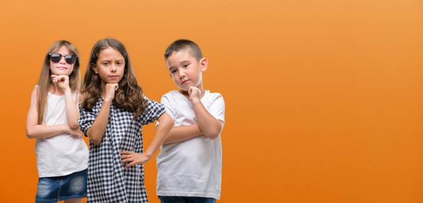 Ryhmä poika ja tyttö lapset oranssi tausta vakava kasvot ajatella kysymys, hyvin sekava ajatus
 - Valokuva, kuva