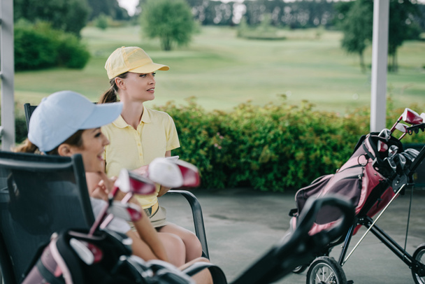 vue latérale des femmes en casquettes se reposant après le jeu de golf au terrain de golf
 - Photo, image