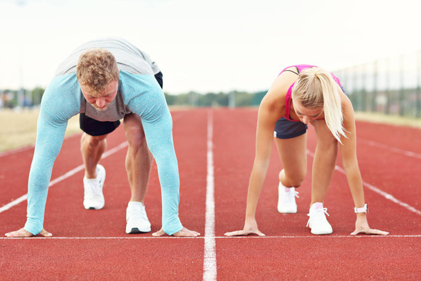 Man and woman racing on outdoor track - Foto, Bild